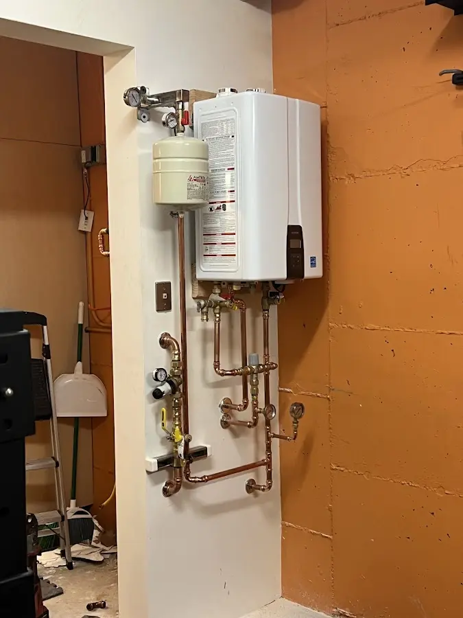 Plumbing technician inspecting water heater connections in Danville